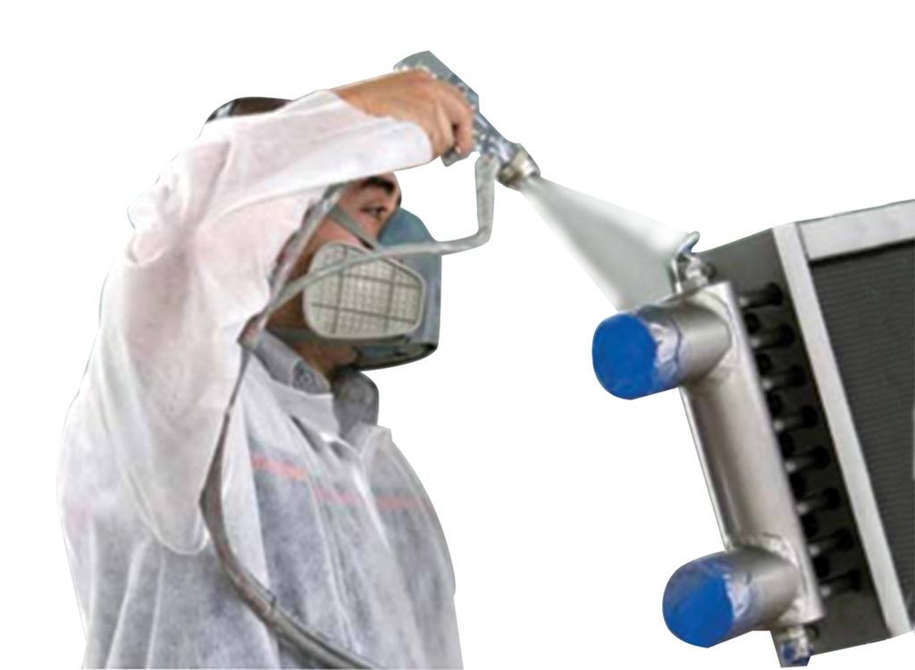 man spraying anti-corrosive spray on a heat exchanger