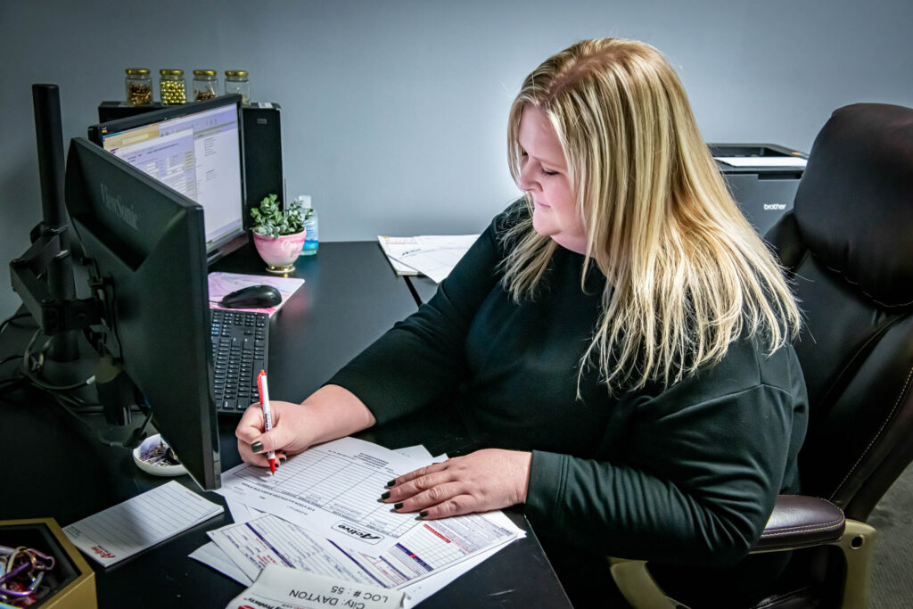 customer service staffer writing on paperwork at her desk at Active Radiator