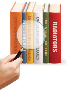 a hand holding a magnifying glass over various books about heavy equipment parts